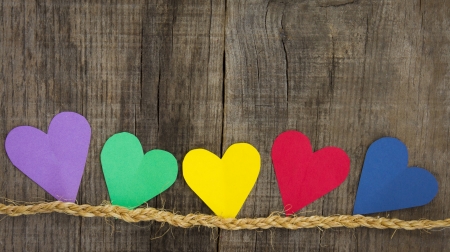 Colorful paper hearts on wood textured backgroundの写真素材
