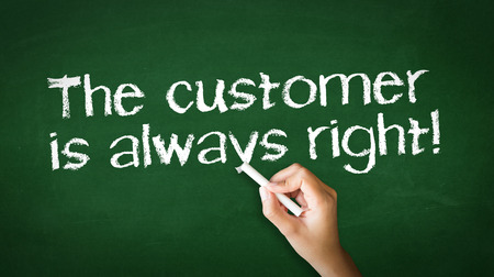 A person drawing and pointing at a The customer is always right Chalk Illustrationの写真素材