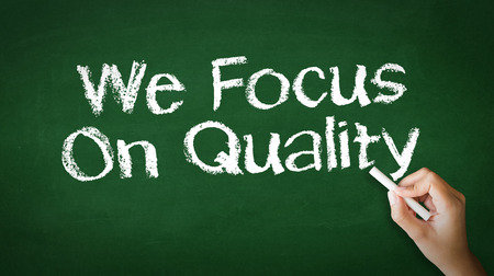 A person drawing and pointing at a We Focus On Quality Chalk Illustrationの写真素材