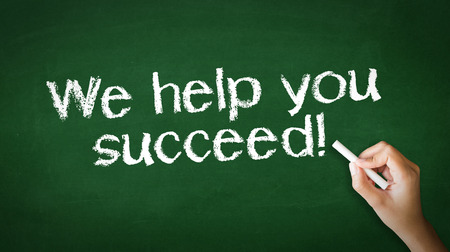 A person drawing and pointing at a We help you succeed Chalk Illustrationの写真素材