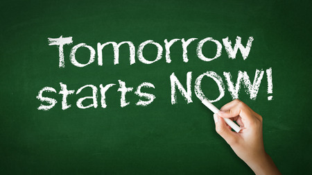 A person drawing and pointing at a Tomorrow starts Now Chalk Illustrationの写真素材