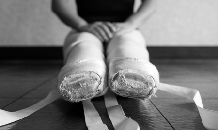 Black and white version of Ballet pointe shoes on a young female ballerina untied in ballet classの写真素材