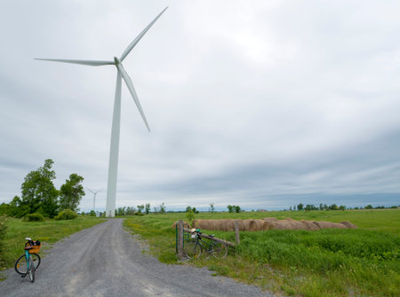 Wind turbine on a cloudy day with bikes in the foreground