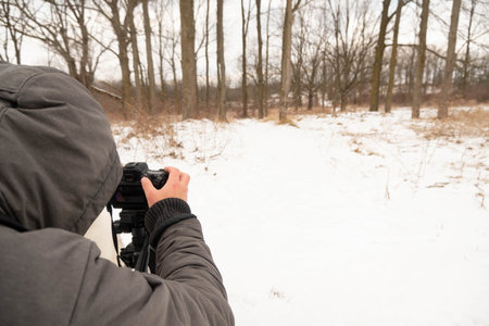 London, Canada, January 19, 2021: Editorial photo of a man in a grey jacket taking pictures outside....