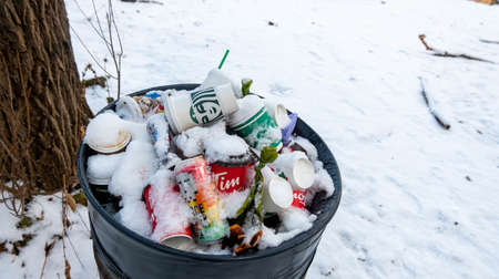 Hamilton, Canada, January 19, 2021: editorial photo of garbage can with colourful garbage on hiking trail.のeditorial素材