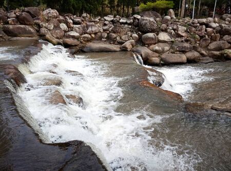 Waterfall line and rocks along the bank of the riverの写真素材