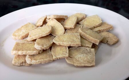 Fried slided soybean cake on white plate in closeup pictureの写真素材