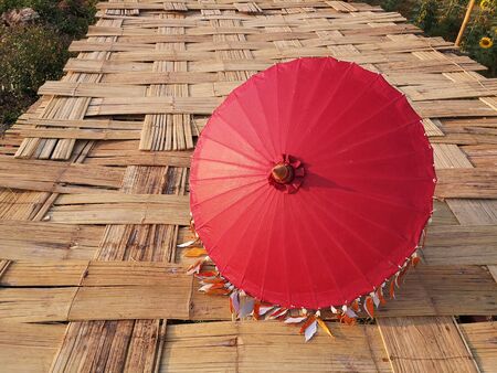 The red umbrella is beautifully decorated. Placed on a bamboo floor の写真素材