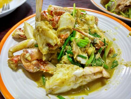 Stir-fried crab with curry powder on a wooden tableの写真素材