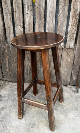 Rounded Wooden chair and old wooden fence in the background
