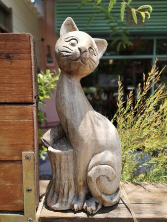 A carved wooden cat laying on the wall with a blurred background and clipping pathの写真素材