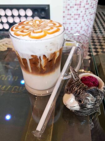 Caramel popcorn Macchiato ice coffee on glass table with blurred backgroundの写真素材
