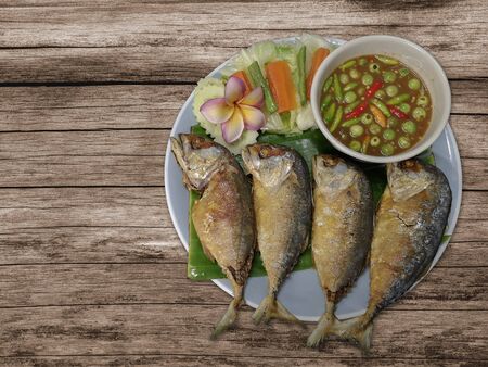 Fried Mackerel with boiled vegetables as a side dish and shrimp Chili Paste sauce On a wooden backgroundの写真素材