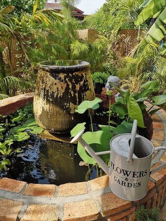 The pond has decorative items in the outdoor green garden.の写真素材