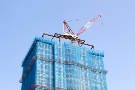 construction site with tower crane over blue skyのeditorial素材