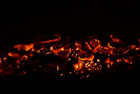 Embers in the barbecue, with an orange bright color. Front view, in outside and without character.
