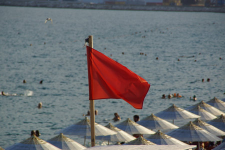 A red flag with the Antalya sea in the background, in southern Turkey.の写真素材