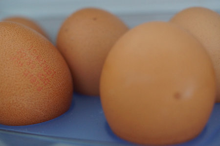 An assortment of eggs rests gently on a neutral surface, highlighting their perfect curves and...