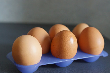 An assortment of eggs rests gently on a neutral surface, highlighting their perfect curves and...