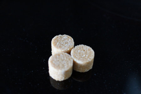 Brown sugar cubes shimmer under the light, revealing their perfect cubic shapes and delicate...