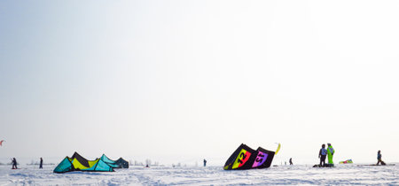A lot of people do snowkiting. Parachuting in snowy terrain. Winter tentsの写真素材
