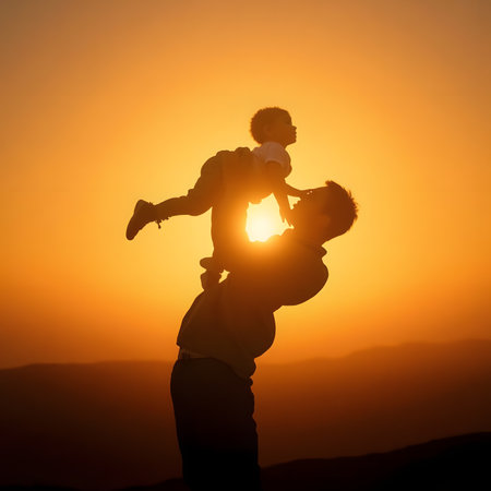 Silhouette of father and son playing at sunset. Concept of friendly family.の素材