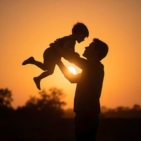 Silhouette of father and son playing on sunset sky background.の素材