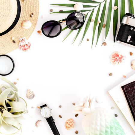 Traveler accessories on white background with retro camera, straw hat, sunglasses and tropical palm leaf. Essential vacation items, Travel conceptの写真素材