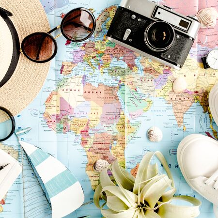 Traveler accessories on map background with retro camera, straw hat, bag, sunglasses. Top view travel or vacation concept. Flat lay, top view.の写真素材