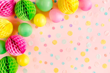 Balloons and confetti on pink background. Birthday, holiday concept. Flat lay, top view. Birthday party backgroundの写真素材