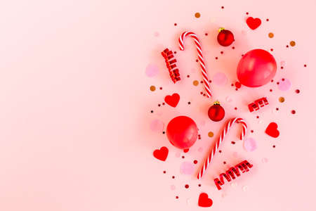 Red box with confetti, balloons, streamers and decoration on a pink background. Colorful...