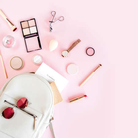 Women beige backpack and accessories on pink background top view. Flat lay female style look. Top view.の写真素材