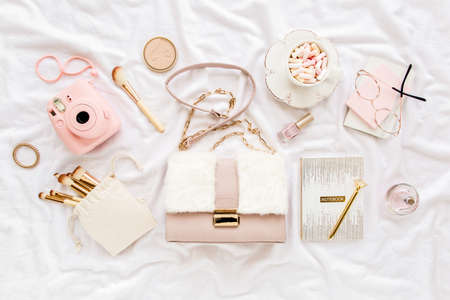 Pink handbag, camera, makeup brushes, cosmetics, sunglasses, accessories on white background. Flat composition. social media. Top view. Flat lay.の写真素材