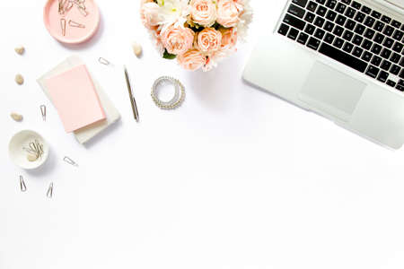 Stylized womens desk, office desk. Workspace with, laptop, roses, clipboard. Womens fashion accessories on white background. Flat lay Top viewの写真素材