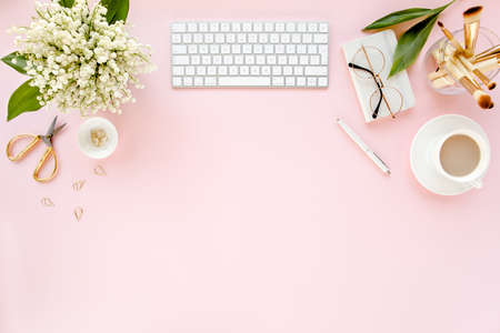 Office table desk with computer, lilac, clipboard. magazines. Top view Flat lay. Home office workspace. Womens fashion accessories on pink backgroundの写真素材