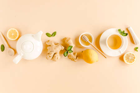 Herbal tea with mint, ginger, lemon, honey and other herbs on yellow background. Flat lay, top view.