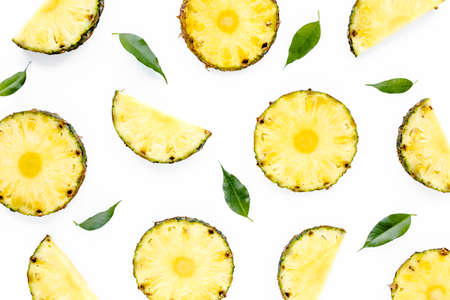 Slices pineapple with green leaves isolated on white background. Flat lay, top viewの写真素材