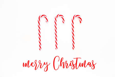 Merry Christmas card with Candy cane. Candies on white background. Flat lay, top view.の写真素材