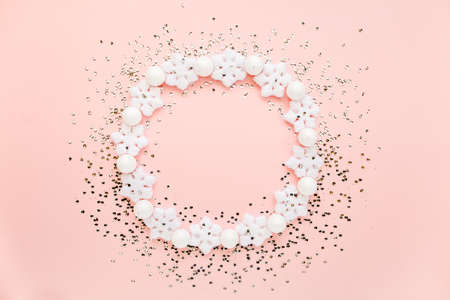 Holiday round frame made of christmas white snowflakes on pink background. Christmas composition, wallpaper. Flat lay, top viewの写真素材