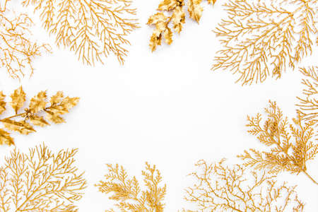 Christmas or new year frame composition. Pattern made of golden leaves on white background. Flat...