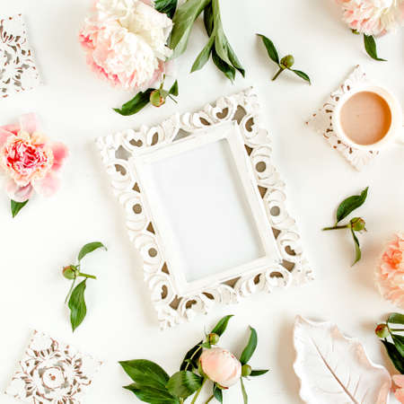 Carved, white frame decorated of beautiful pink peonies on white background. Flat lay, top view....