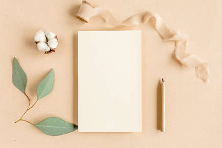 Mockup invitation, blank greeting card and green leaves eucalyptus. Flat lay, top view.の写真素材