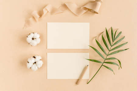 Mockup invitation, blank greeting card and tropical palm leaves. Flat lay, top view.の写真素材