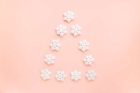 Christmas tree is made from a white toys on pink background. Christmas composition, wallpaper. Flat...