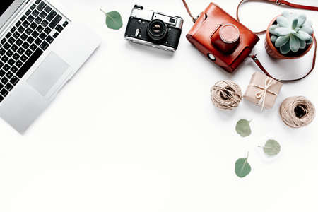 Office table desk. laptop, computer, camera, succulent. Flat composition, magazines, social media...