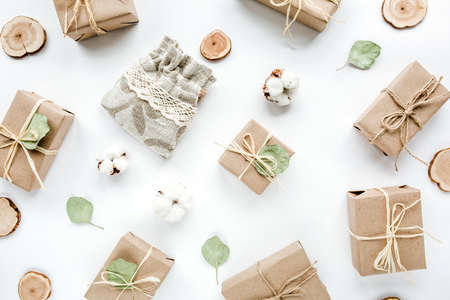 christmas toys and craft boxes. creative arrangement frame of craft boxes and green branches eucalyptus on white background. flat lay, top viewの写真素材