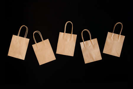 Black Friday sales discount concept. Craft paper bags with word Sale on black background.の写真素材