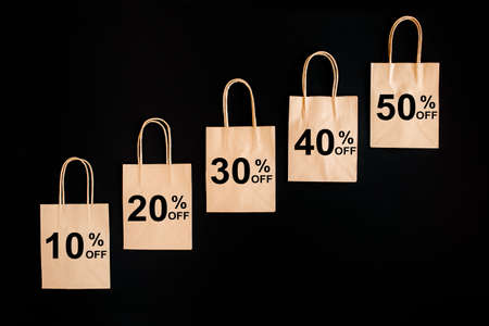 Black Friday sales discount concept. Craft paper bags with word Sale on black background.の写真素材