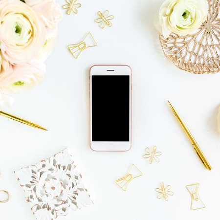 Workspace with diary, gold accessories, ranunculus flowers on white background. Home office desk. Top view feminine background. Flat lay, top view.の写真素材