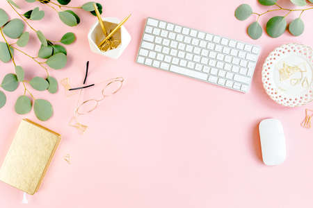 Office table desk with computer, green leaves eucalyptus, clipboard, golden accessories, diary, glasses. Magazines, social media. Top view. Flat lay.の写真素材